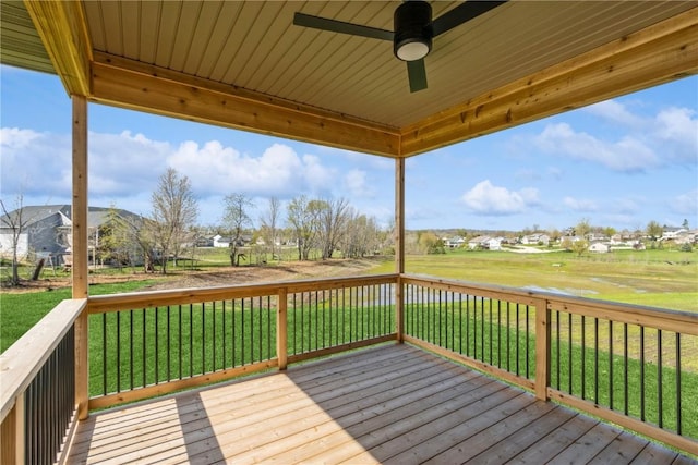 wooden terrace featuring a lawn and ceiling fan