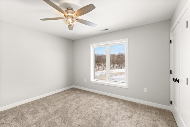 carpeted spare room featuring ceiling fan