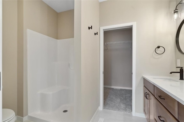 bathroom with toilet, vanity, and walk in shower