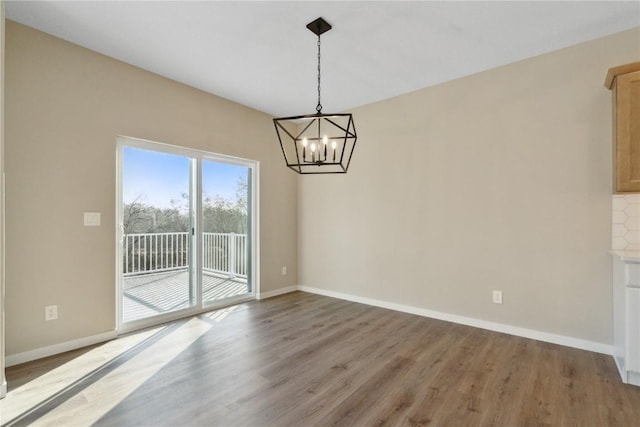 unfurnished dining area featuring hardwood / wood-style floors and an inviting chandelier