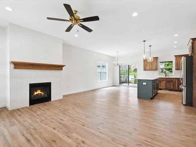 261 Colchester Dr, Iowa City, IA 52245 - unfurnished living room featuring light wood-style floors, plenty of natural light, a glass covered fireplace, ceiling fan, and recessed lighting