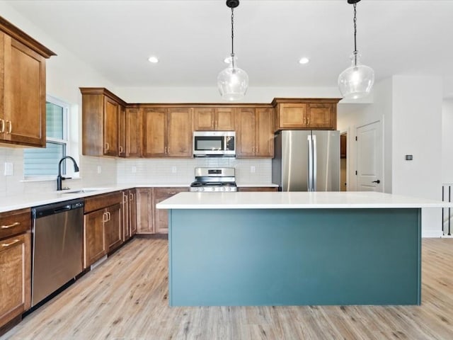 261 Colchester Dr, Iowa City, IA 52245 - kitchen featuring appliances with stainless steel finishes, a sink, a center island, light wood-style flooring, and recessed lighting