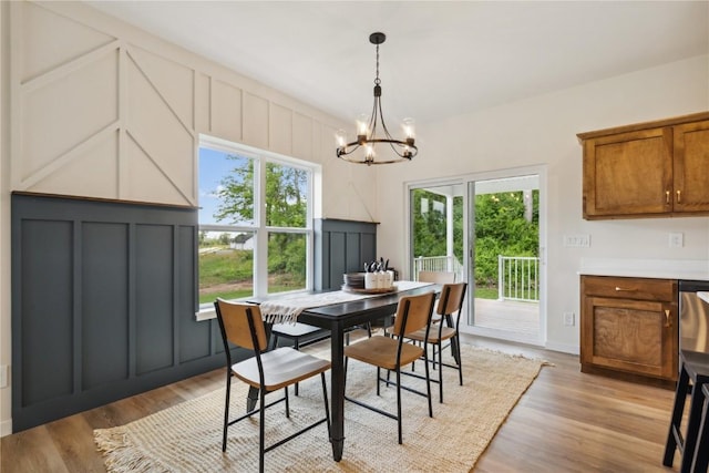 dining space featuring light wood-type flooring and a chandelier