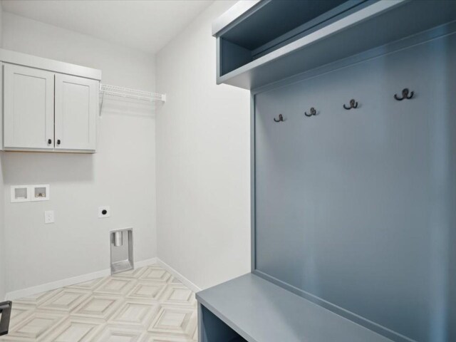 washroom with electric dryer hookup, hookup for a washing machine, and cabinets