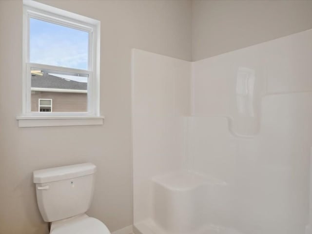 bathroom featuring walk in shower and toilet