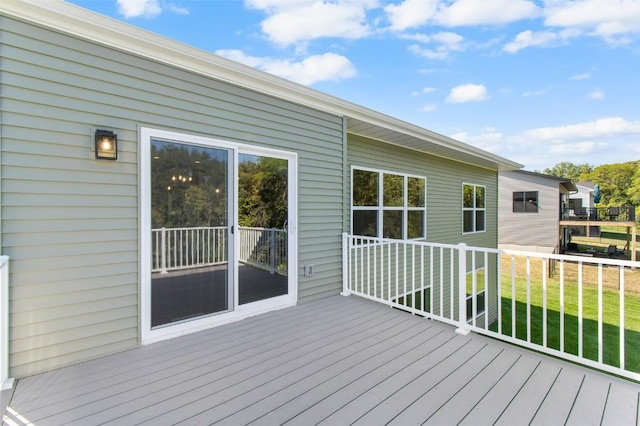 wooden deck featuring a lawn