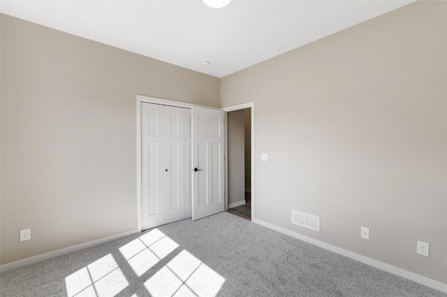 unfurnished bedroom featuring light carpet and a closet