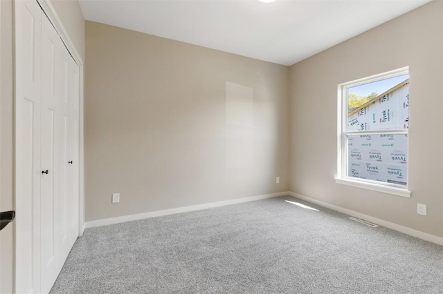 unfurnished bedroom featuring carpet floors, a closet, and multiple windows