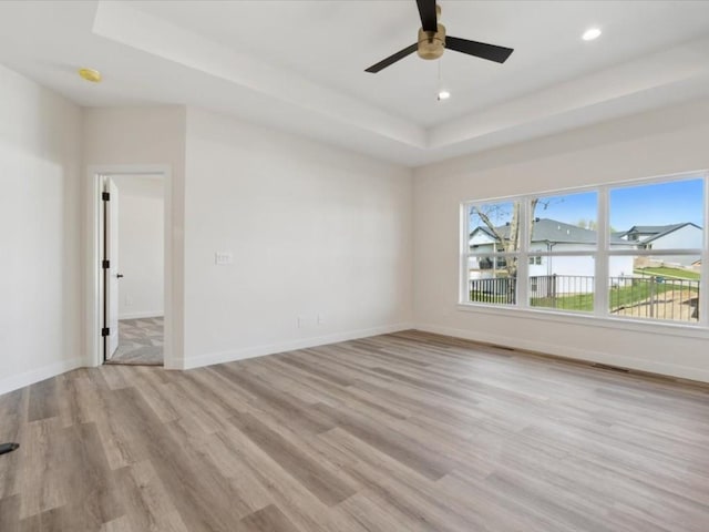 1501 Legend Dr, Tiffin, IA 52340 - unfurnished room featuring a tray ceiling, light wood-type flooring, ceiling fan, baseboards, and recessed lighting