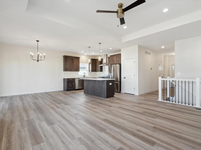 1501 Legend Dr, Tiffin, IA 52340 - kitchen with stainless steel appliances, wall chimney range hood, open floor plan, a kitchen island, and recessed lighting