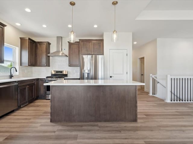 1501 Legend Dr, Tiffin, IA 52340 - kitchen with wall chimney range hood, stainless steel appliances, a sink, a center island, and decorative backsplash