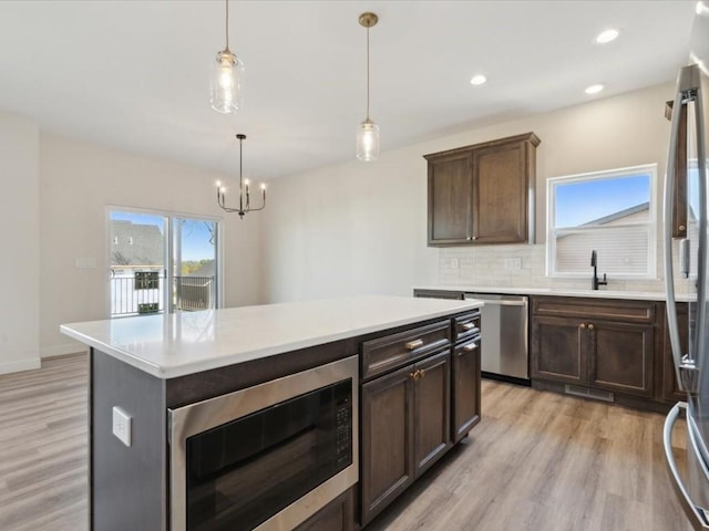 1501 Legend Dr, Tiffin, IA 52340 - kitchen featuring stainless steel appliances, light wood-style floors, decorative backsplash, light countertops, and recessed lighting