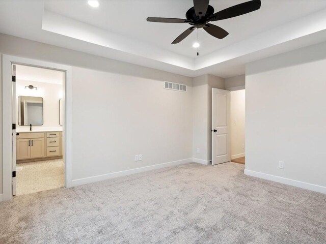 314 Sierra Trce, Coralville, IA 52241 - unfurnished bedroom featuring a tray ceiling, light carpet, connected bathroom, and recessed lighting