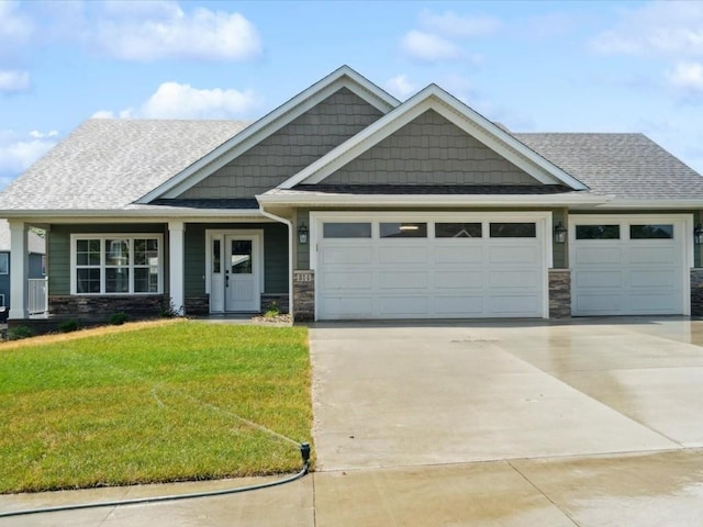 314 Sierra Trce, Coralville, IA 52241 - craftsman-style house featuring an attached garage, concrete driveway, a front yard, stone siding, and a shingled roof