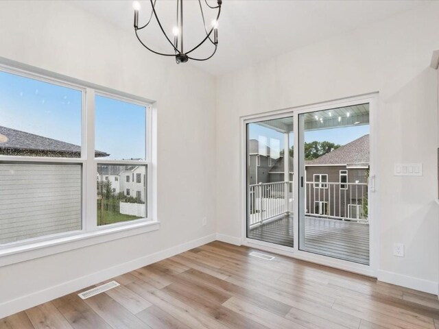 314 Sierra Trce, Coralville, IA 52241 - unfurnished room with a chandelier and wood finished floors