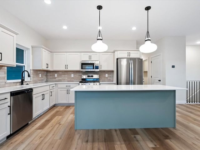 314 Sierra Trce, Coralville, IA 52241 - kitchen with appliances with stainless steel finishes, tasteful backsplash, a kitchen island, light wood-type flooring, and light countertops