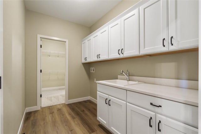 clothes washing area featuring sink and hardwood / wood-style floors