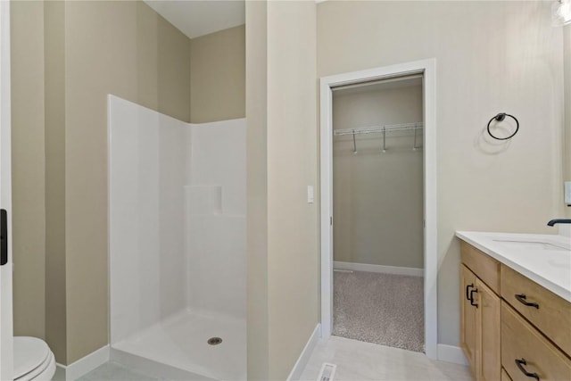 bathroom with vanity, toilet, and a shower