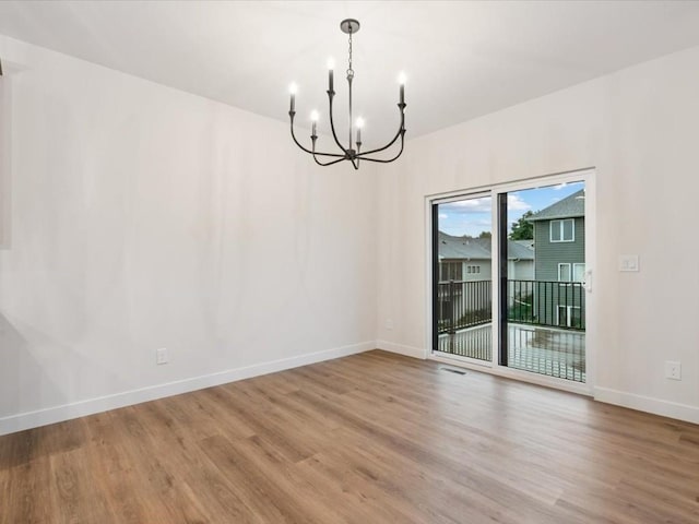 318 Sierra Trce, Coralville, IA 52241 - spare room with a chandelier and wood finished floors