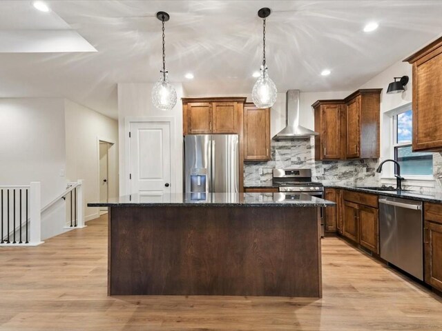 318 Sierra Trce, Coralville, IA 52241 - kitchen featuring stainless steel appliances, wall chimney range hood, a center island, dark stone counters, and decorative backsplash
