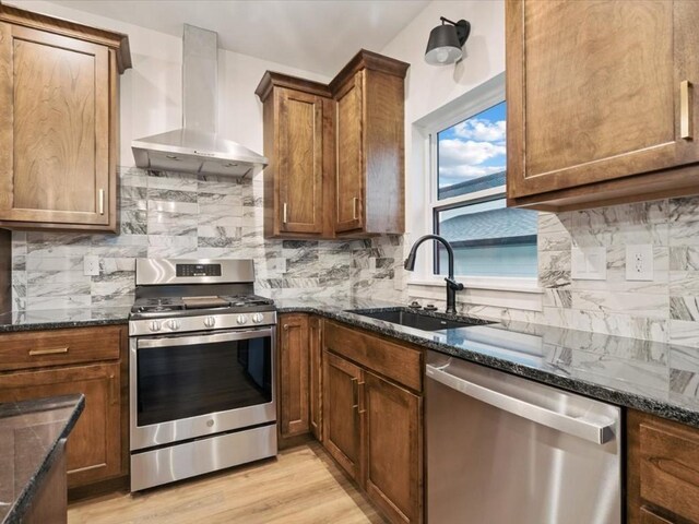 318 Sierra Trce, Coralville, IA 52241 - kitchen featuring appliances with stainless steel finishes, island range hood, dark stone countertops, backsplash, and light wood finished floors