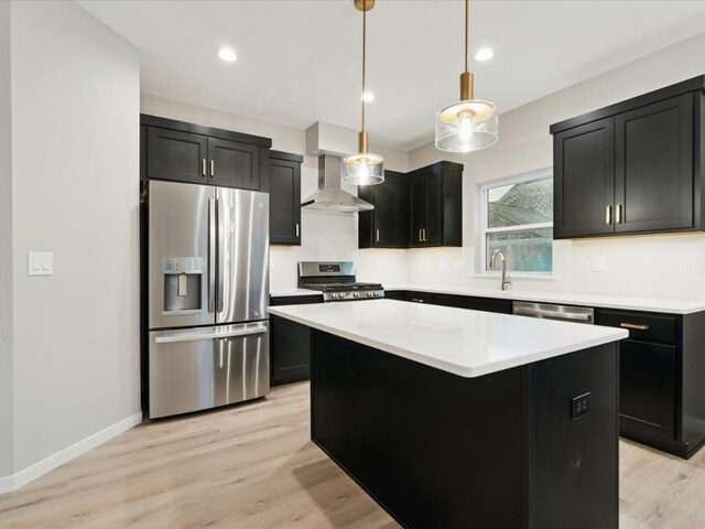 322 Sierra Trce, Coralville, IA 52241 - kitchen with appliances with stainless steel finishes, wall chimney range hood, dark cabinetry, a kitchen island, and recessed lighting