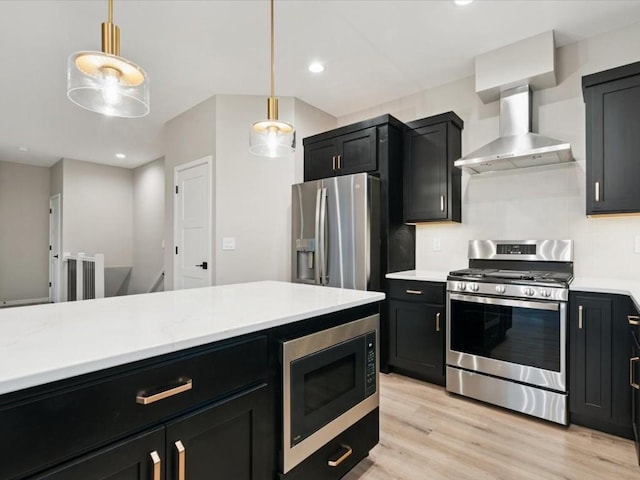 322 Sierra Trce, Coralville, IA 52241 - kitchen featuring stainless steel appliances, wall chimney exhaust hood, dark cabinetry, hanging light fixtures, and recessed lighting
