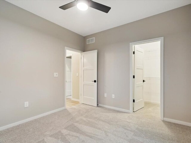 322 Sierra Trce, Coralville, IA 52241 - unfurnished bedroom with light colored carpet, a walk in closet, and ceiling fan