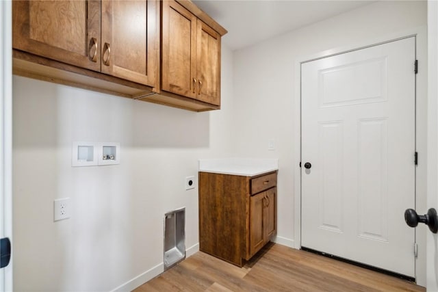 laundry area with washer hookup, electric dryer hookup, cabinets, and light wood-type flooring