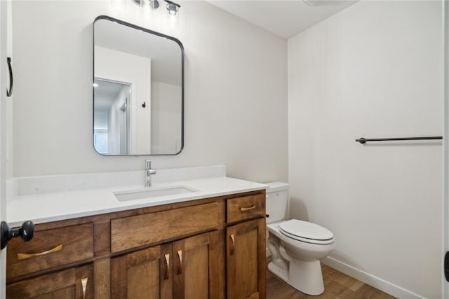 bathroom with hardwood / wood-style floors, vanity, and toilet