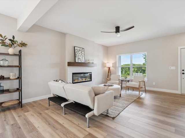 4648 Preston Ln, Iowa City, IA 52246 - living room featuring ceiling fan, a glass covered fireplace, and light wood-style flooring