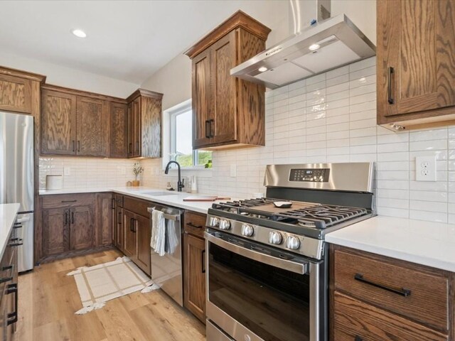 4648 Preston Ln, Iowa City, IA 52246 - kitchen featuring appliances with stainless steel finishes, extractor fan, light wood-style floors, backsplash, and recessed lighting