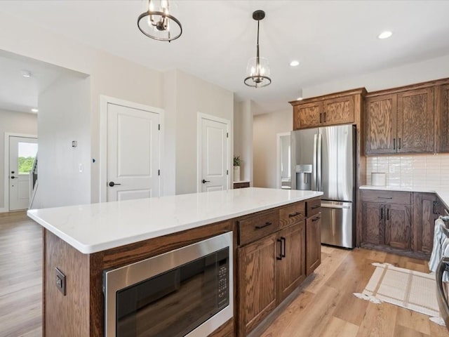 4648 Preston Ln, Iowa City, IA 52246 - kitchen featuring appliances with stainless steel finishes, light wood finished floors, backsplash, light countertops, and recessed lighting