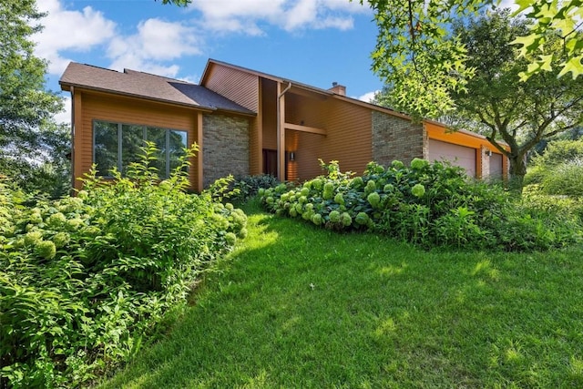 view of property exterior with a lawn and a garage