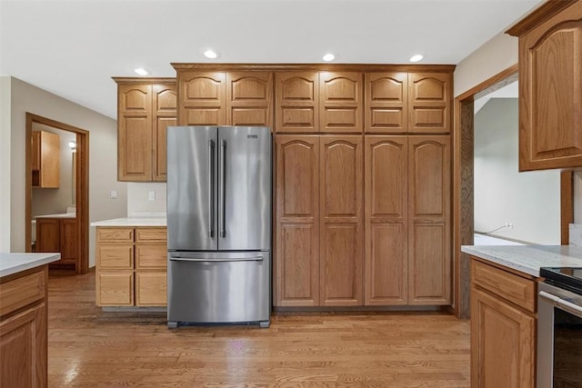 kitchen with range, light wood-type flooring, and stainless steel refrigerator