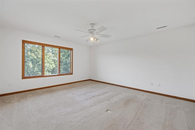 carpeted spare room featuring ceiling fan