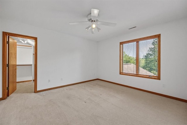 spare room featuring ceiling fan and light colored carpet