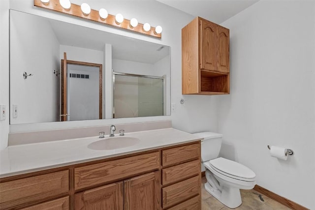 bathroom featuring tile patterned flooring, vanity, toilet, and walk in shower