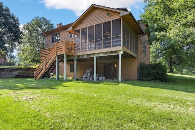 rear view of house featuring a lawn, a sunroom, and a deck