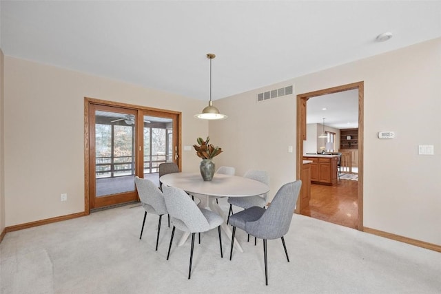 dining space featuring light carpet and french doors