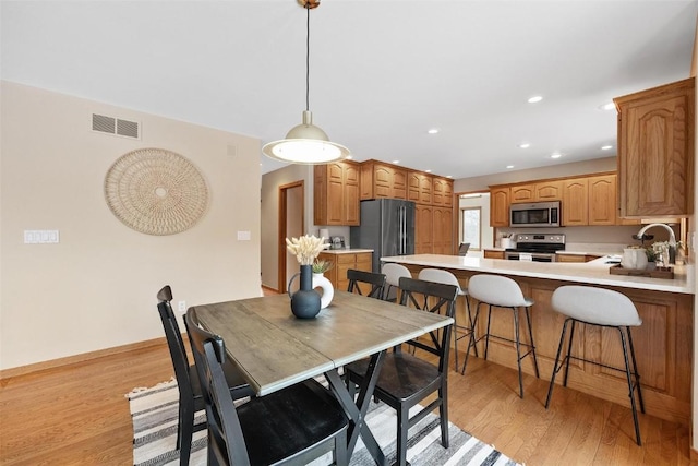 dining room featuring light wood-type flooring and sink