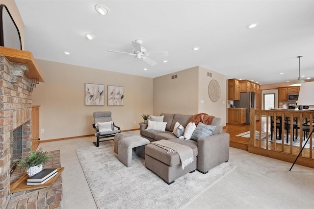 living room featuring ceiling fan, light carpet, and a brick fireplace