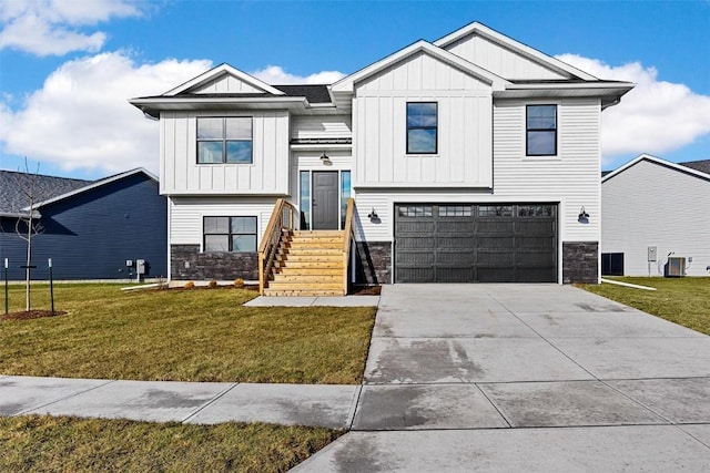 view of front facade featuring a garage, a front yard, and central AC