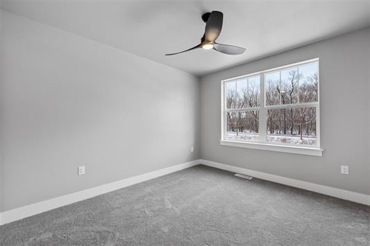 carpeted empty room featuring ceiling fan