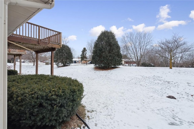 yard covered in snow with a wooden deck