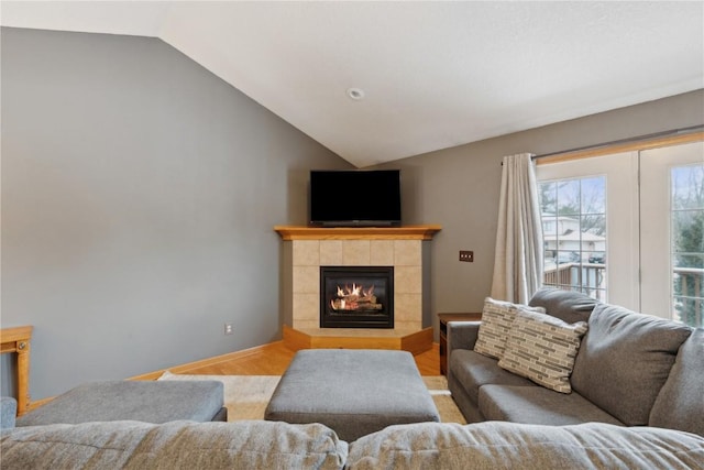 living room with a fireplace, light hardwood / wood-style floors, and lofted ceiling