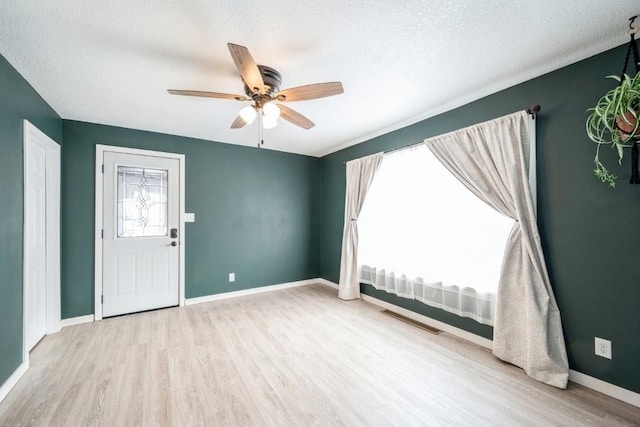 unfurnished room with ceiling fan, a textured ceiling, and light hardwood / wood-style flooring