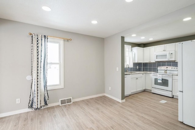 kitchen featuring white cabinetry, white appliances, light hardwood / wood-style flooring, and decorative backsplash