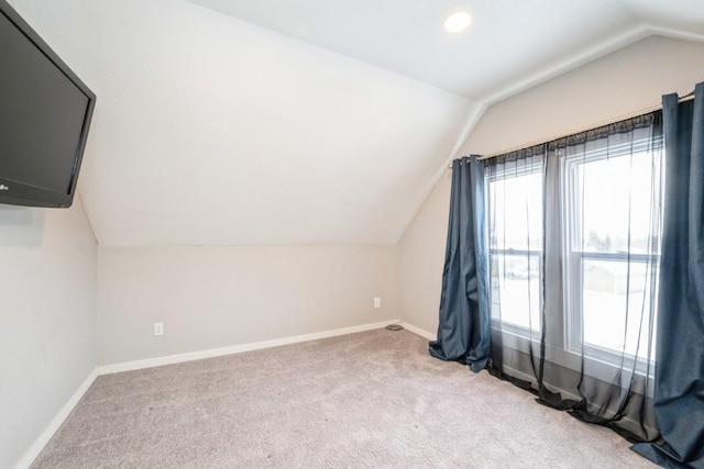 bonus room featuring light colored carpet and vaulted ceiling