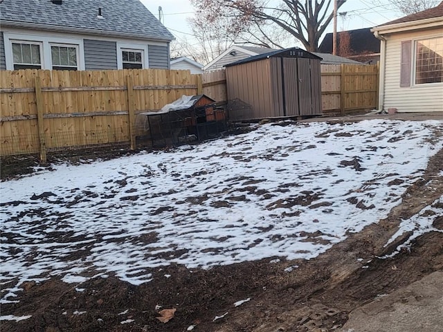 yard layered in snow with a storage shed